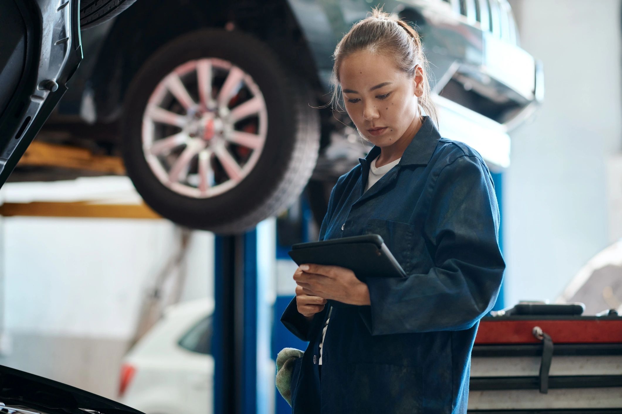 Mechanic holding a tablet while performing a system check
