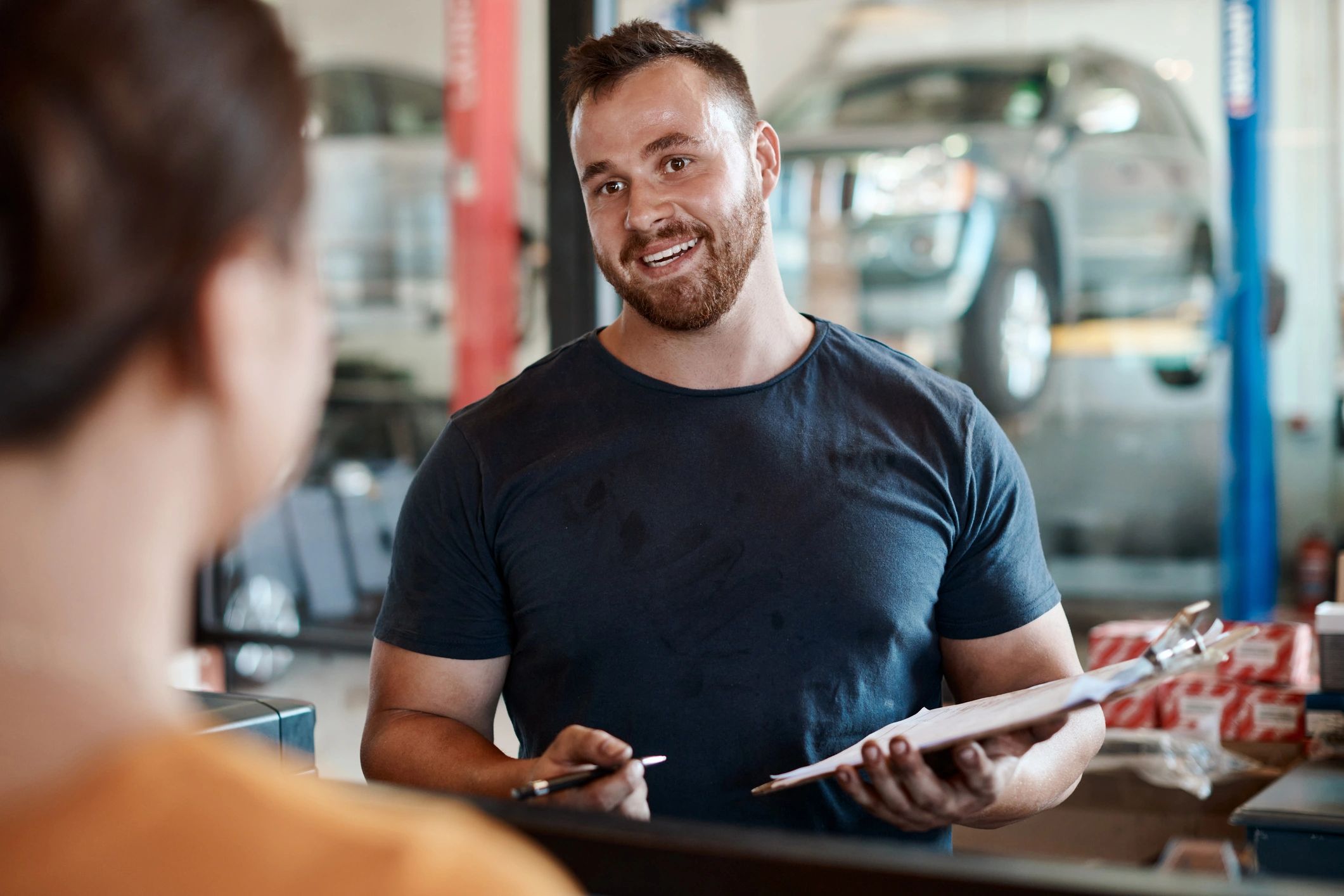 Customer speaking with a mechanic at an auto repair shop