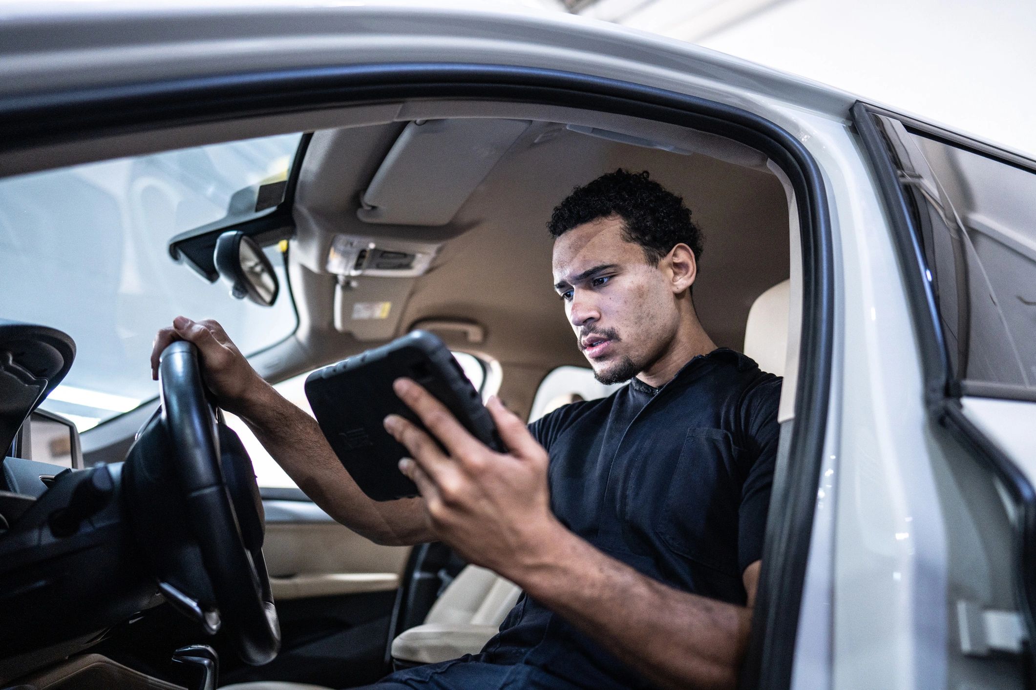 Mechanic using a digital tablet inside a car during diagnostics