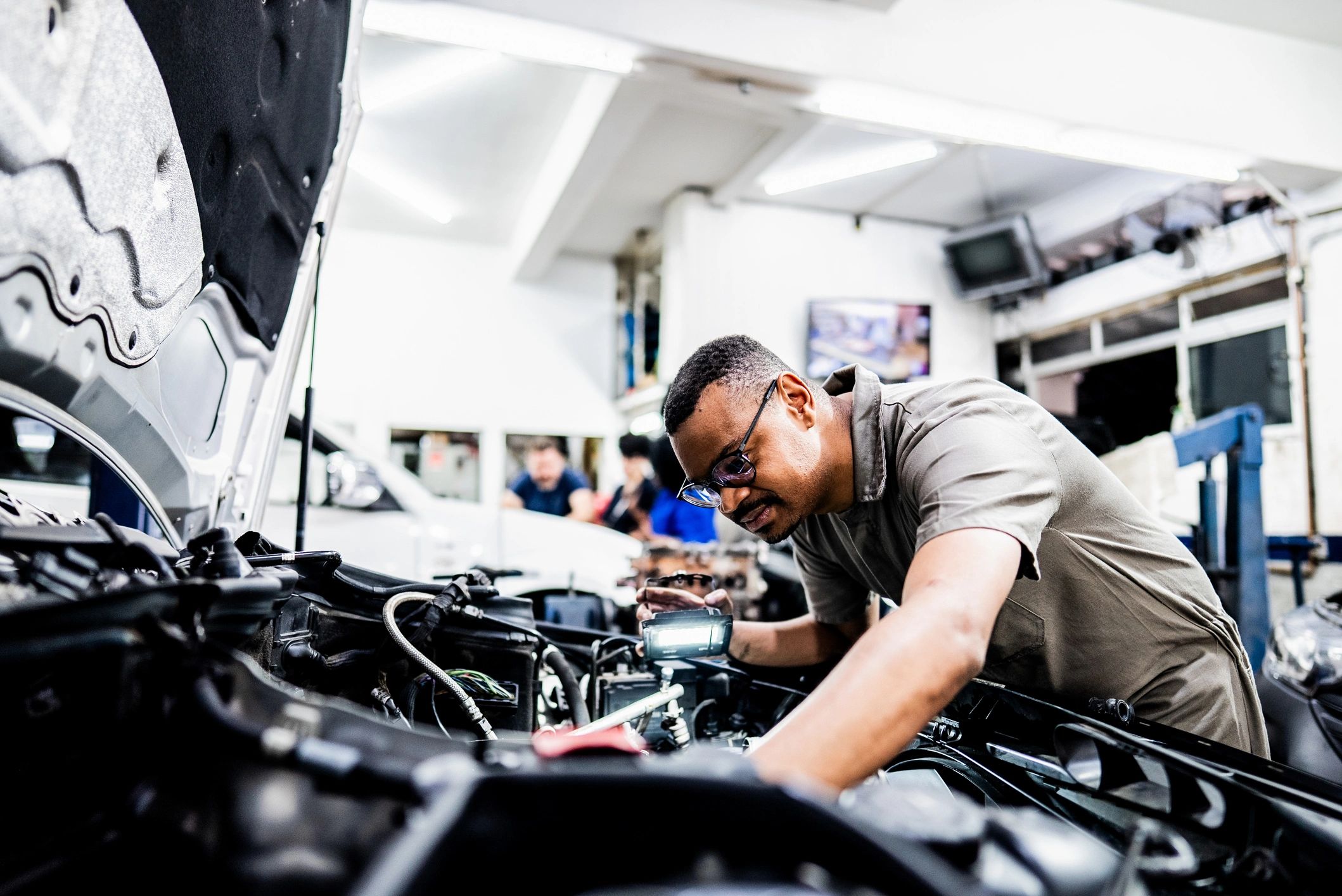 Technician performing transmission service in an auto repair bay
